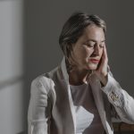 Femme assise qui se tient la tête