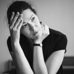 Femme assise qui se tient le front