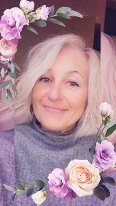 Une photo de moi avec des fleurs rose, je suis une femme blonde aux yeux verts